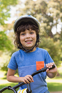 穿着自行车头盔的小可爱男孩公园男生享受男性学习微笑安全农村乐趣背景图片