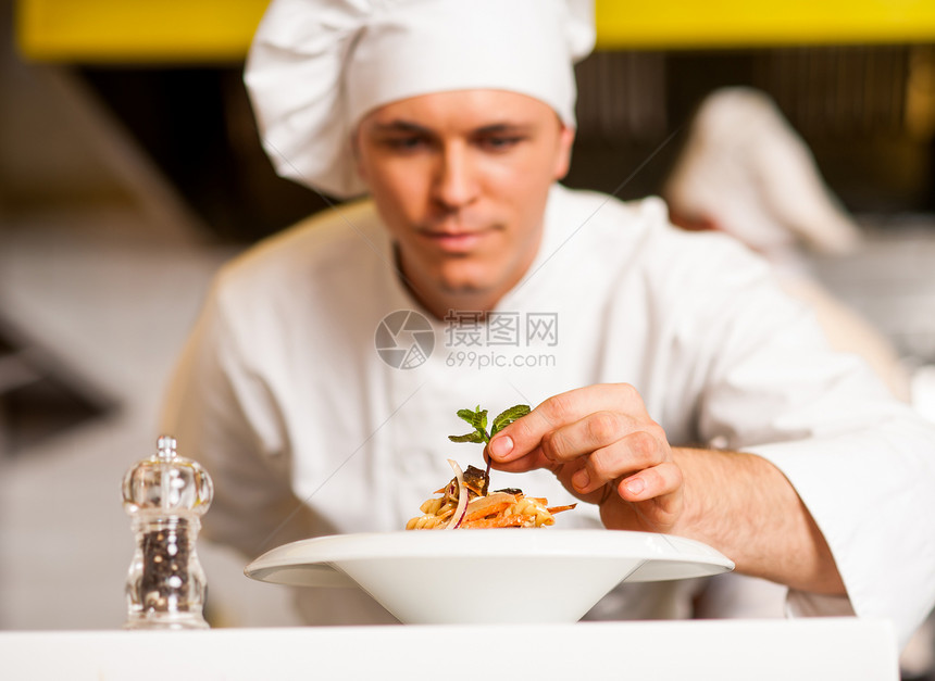 厨师装饰意大利面沙拉和草叶桌子胡椒服务转矩沙拉食物厨房职业男人酒店图片
