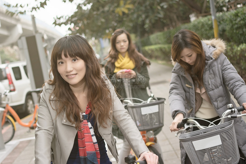 年轻亚洲妇女与朋友一起骑自行车活动女性女士团体运动闲暇魅力友谊生活快乐图片