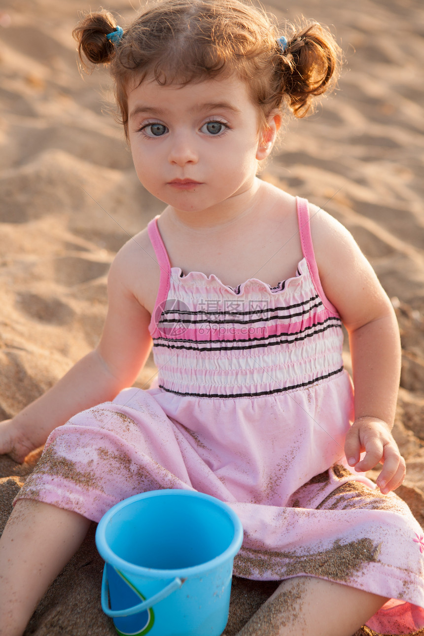 在沙滩上玩沙子的蓝褐色眼睛假期游戏海滩辫子旅行孩子喜悦童年海洋晴天图片