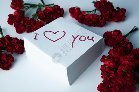 笔记本上写着我爱你和玫瑰情人刻字画板礼物白色宣言背景图片