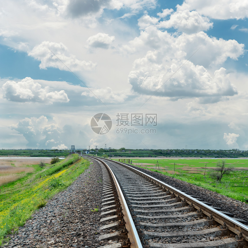 以铁路对地平线和阴云的天空蓝色天堂碎石小路过境旅行基础设施物流阳光戏剧性图片