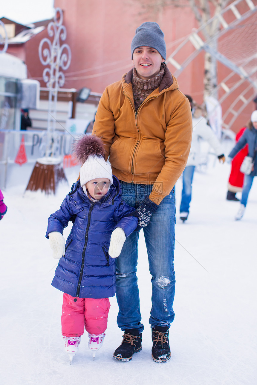 年轻快乐的父亲和可爱的小女孩 在滑冰场上爸爸女儿孩子教学活动滑冰爱好男人乐趣婴儿图片