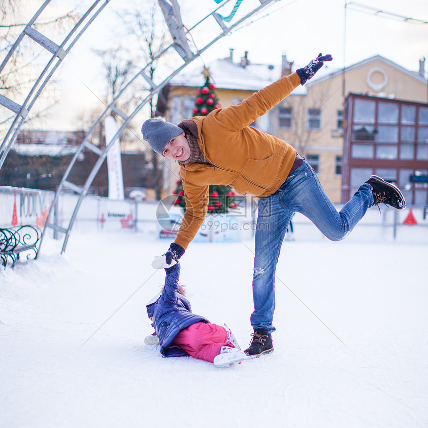 年轻有趣的父亲和可爱的小女孩 在滑冰场上教学女儿训练溜冰场手套家庭微笑小姑娘童年溜冰者图片