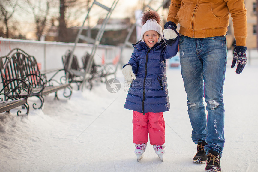 年幼父亲教他女儿滑溜冰在水晶上冰鞋教学训练娱乐小姑娘童年手套女孩父母锻炼图片