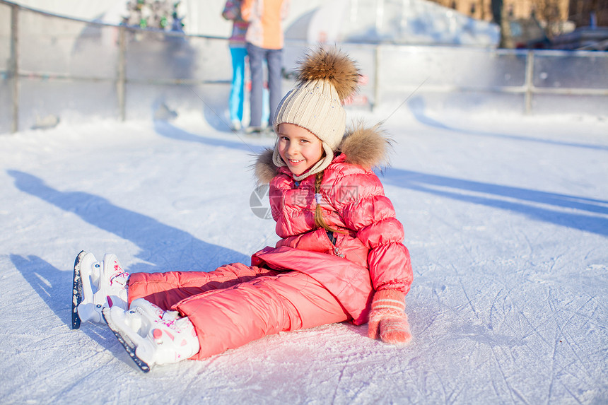 秋天后 可爱的快乐女孩坐在冰上 穿着溜冰鞋坐着冰雪女儿婴儿锻炼学习速度活动冰鞋手套喜悦小姑娘图片