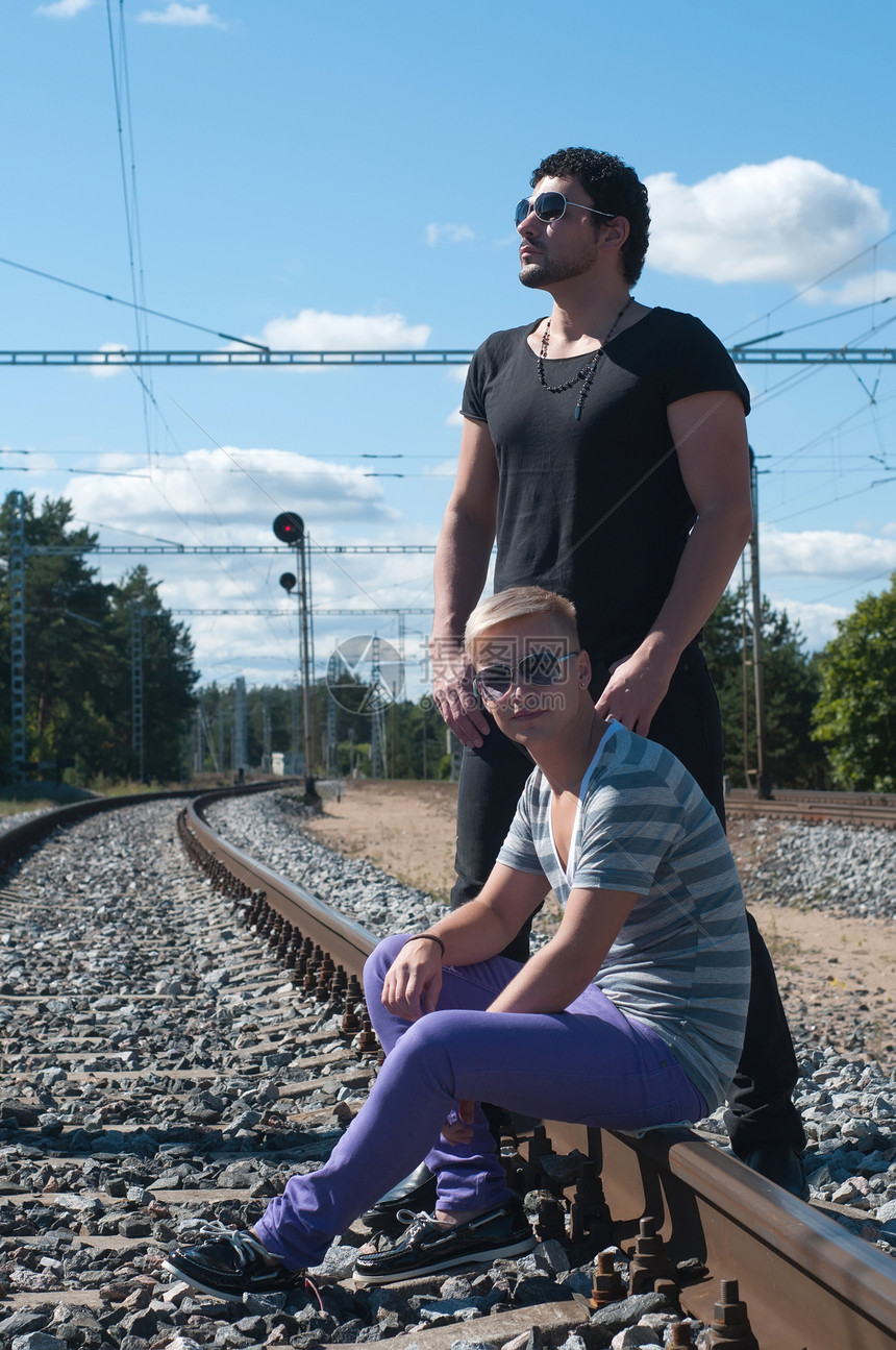 两个青年男子在火车轨上图片