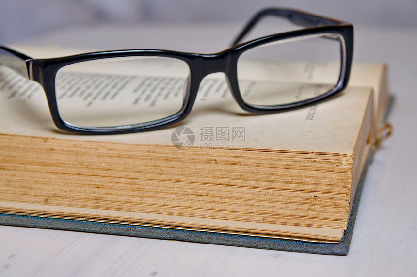 在一本旧书上阅读玻璃杯学习文学字典桌子图书馆数据智慧意义知识科学图片