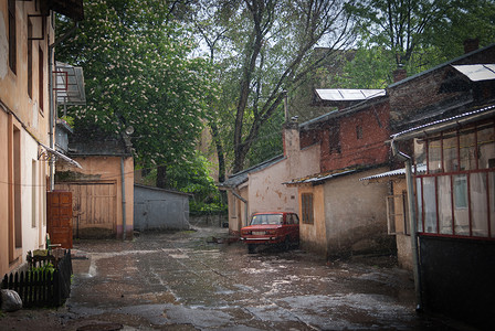 淋雨的车在Lvov的院子里淋雨背景