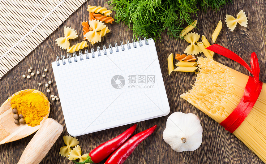 笔记本周围的香料和蔬菜笔记烹饪桌子香蒜文化产品厨房草本植物胡椒午餐图片