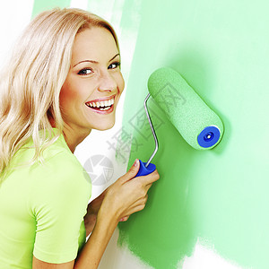 女人画墙壁滚筒装修画家金发房子工具绿色刷子快乐女性背景图片
