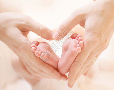 小小小新生婴儿脚踩着女性心脏 手握紧了身体孩子母性母亲家庭生活保健脚趾棕榈压痛背景图片