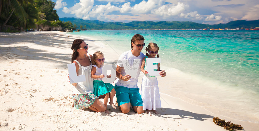 年轻家庭和两个孩子在热带度假时 有爱字词幸福母亲海滨父母父亲男性成人海岸喜悦妈妈图片