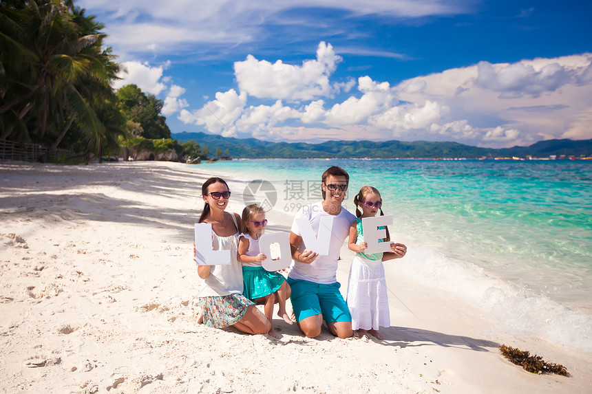 年轻家庭和两个孩子在热带度假时 有爱字词婴儿幸福女士女性女孩父母乐趣海岸成人男性图片