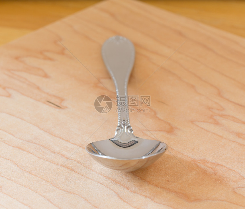 木柴上不锈钢桌子白色餐具金属勺子厨具木头工具反射银器图片