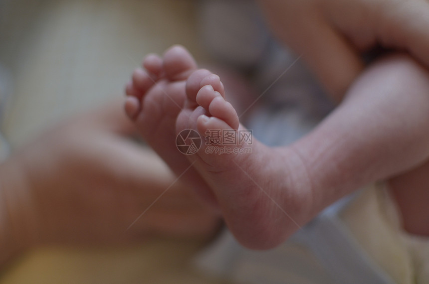 新出生的婴儿脚 与模糊背景连接图片