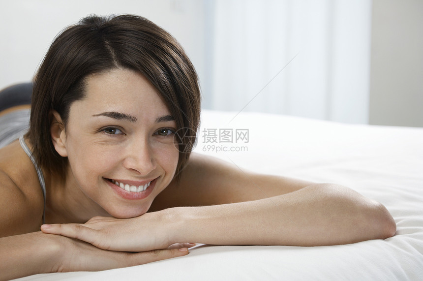 躺在床上肖像上的年轻女人活动一人卧室肩膀成人女性快乐成年头肩头发图片