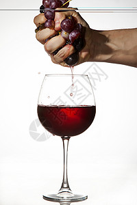 红葡萄用手挤压来酿酒玻璃白色果汁水果社会派对背景图片