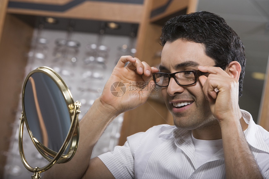 男人在商店里试戴眼镜中年顾客镜子眼镜头肩保健短发店铺快乐男子图片