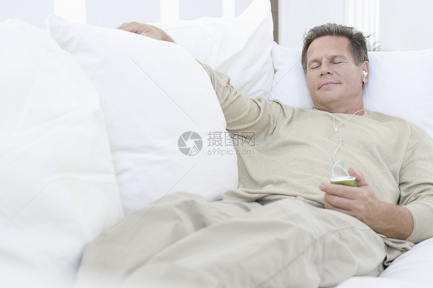 中年人听沙发音乐中年头发男子享受枕头耳机家庭生活闲暇棕色睡眠图片