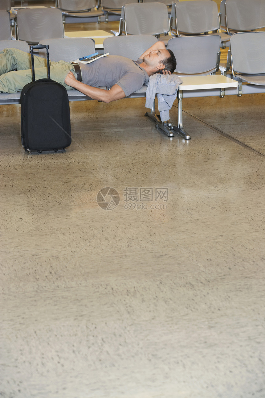 在机场大厅的椅子上坐着旅行者图片