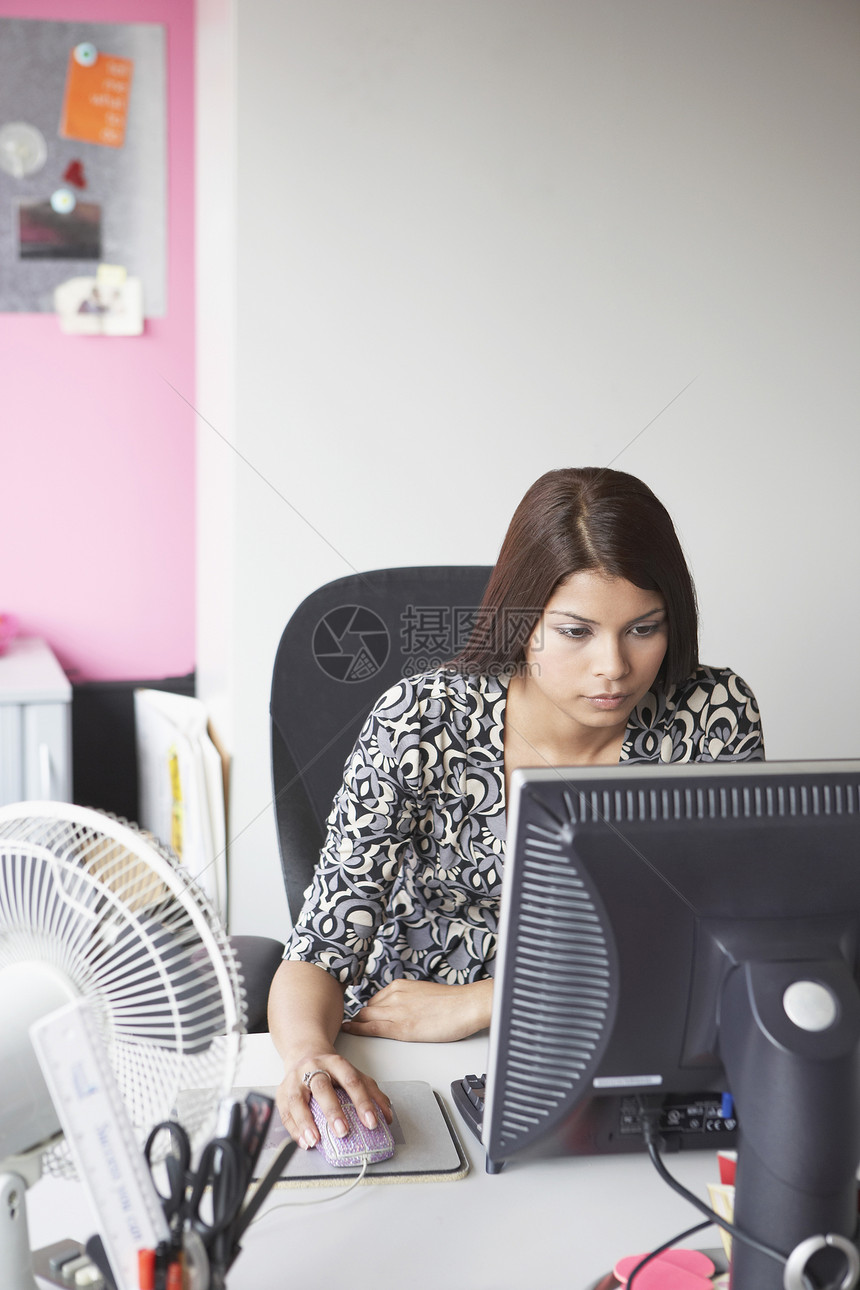 办公室工作人员使用计算机坐在办公桌高视台后面的扇子桌子上班族一人中年中年人服装棕色商业长发图片