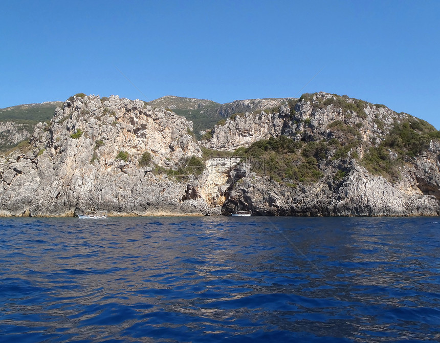 沿海岩石蓝色山脉晴天地平线反射海浪海滩风景石头海岸图片