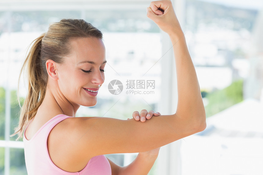 年轻女子健身房的肌肉运动图片