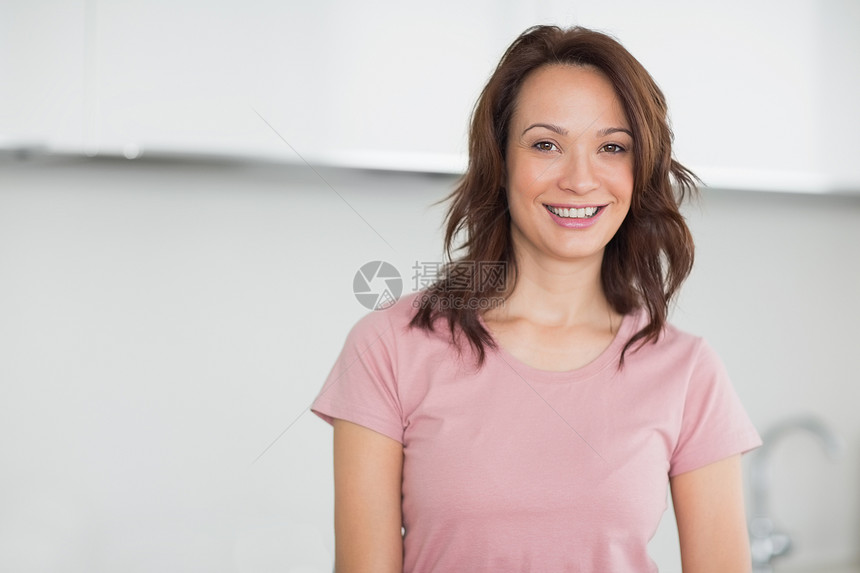 厨房里一个笑着的随意女人的肖像图片
