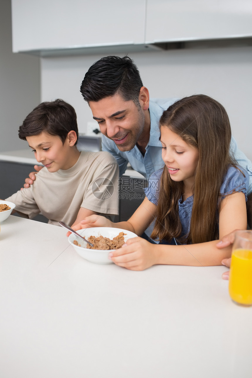 年幼的孩子在厨房和父亲一起享受早餐图片