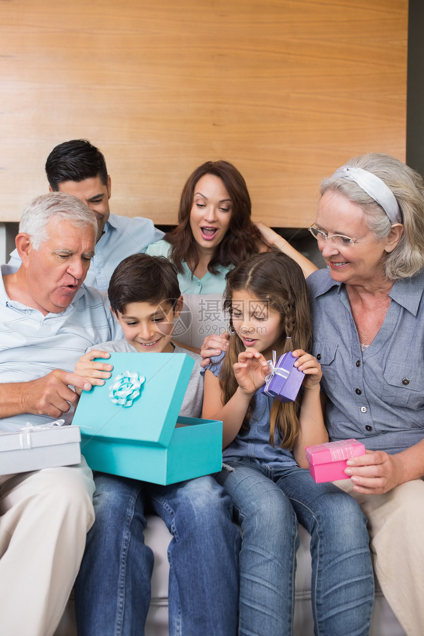 大家庭坐在沙发上 客厅里装着礼品盒祖父母女孩成人男人幸福祖父儿子快乐母亲父亲图片