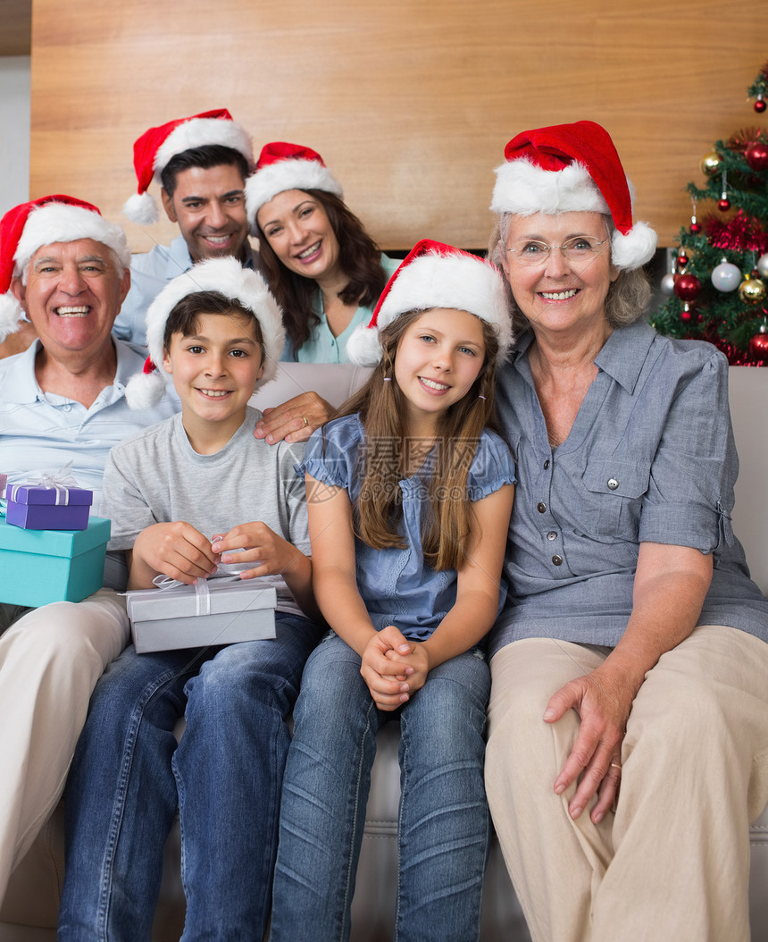 戴圣诞帽子的大家庭 客厅内装礼品盒微笑女儿儿子家庭童年公寓家庭生活礼物盒父亲男生图片