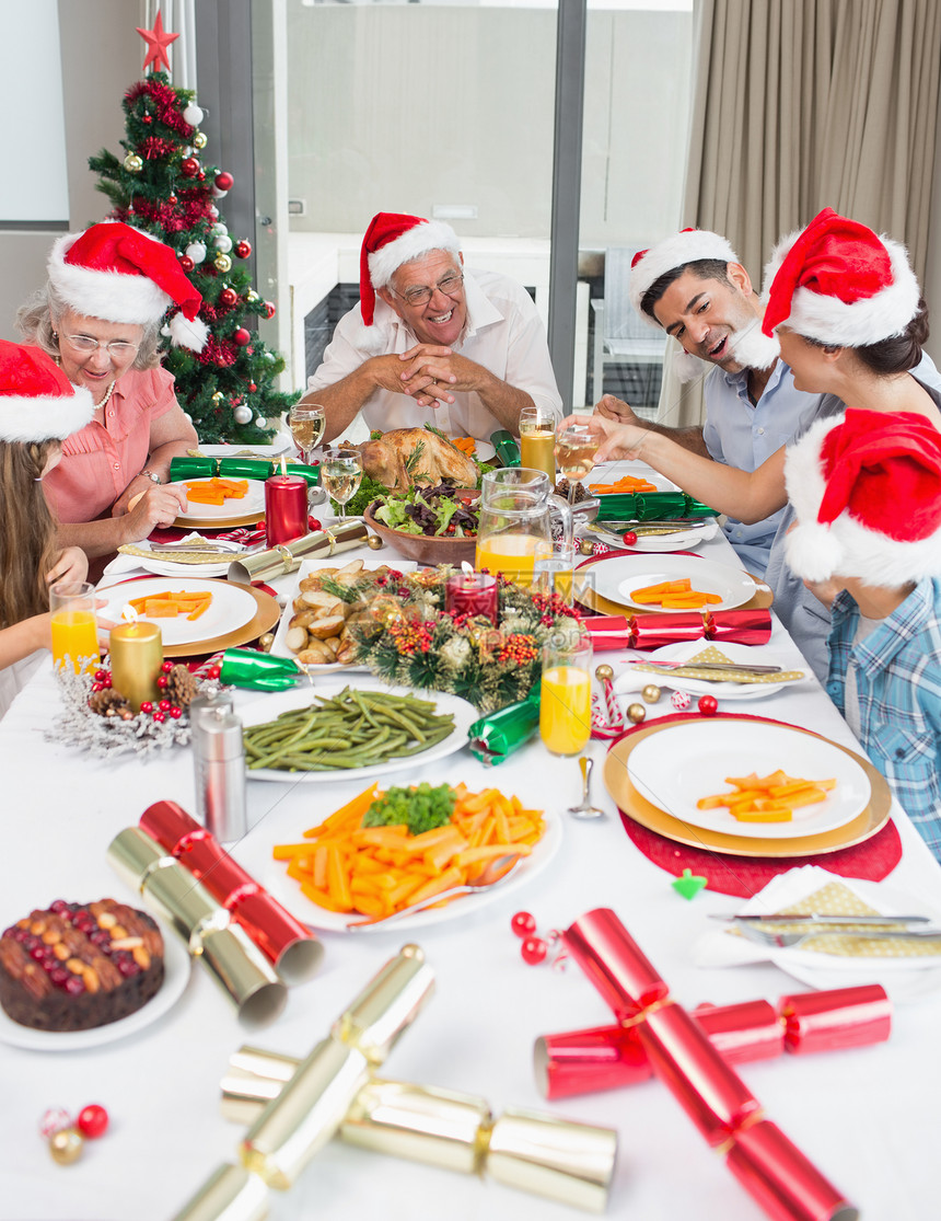 享受圣诞晚宴的圣诞老人帽子家庭快乐图片