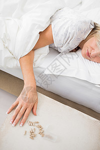 妇女睡在床上 用药丸睡在前台休息药片药品棉被卧室平板家庭生活药剂睡眠女性背景图片