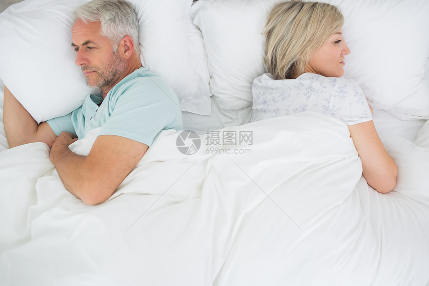 躺在床上的成熟夫妇羽绒被男人说谎家庭生活软垫棉被眼睛男性夫妻床单图片