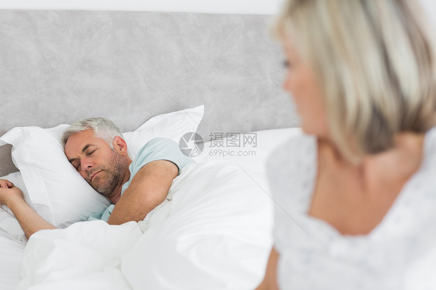与背景男子一起坐在床上的十几岁的成年妇女男人忧郁愁云悲伤睡眠房子思维女性悲哀夫妻图片