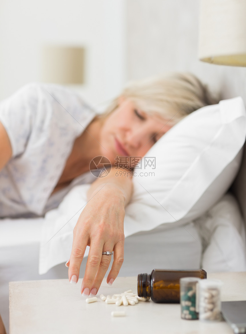 妇女睡在床上 用药丸睡在前台睡眠卧室药品眼睛房子瓶子电脑家庭生活白色女性图片
