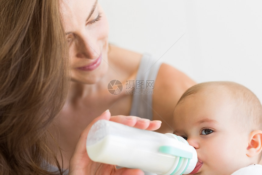 以奶瓶为婴儿喂奶母亲的封闭家长儿童食品家庭孩子关爱闲暇女孩女士房子图片