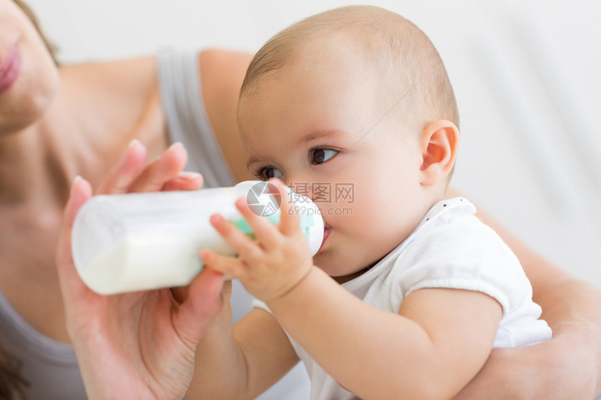 以奶瓶为婴儿喂奶母亲的封闭关爱女性新生家长童年孩子儿童瓶子家庭女士图片
