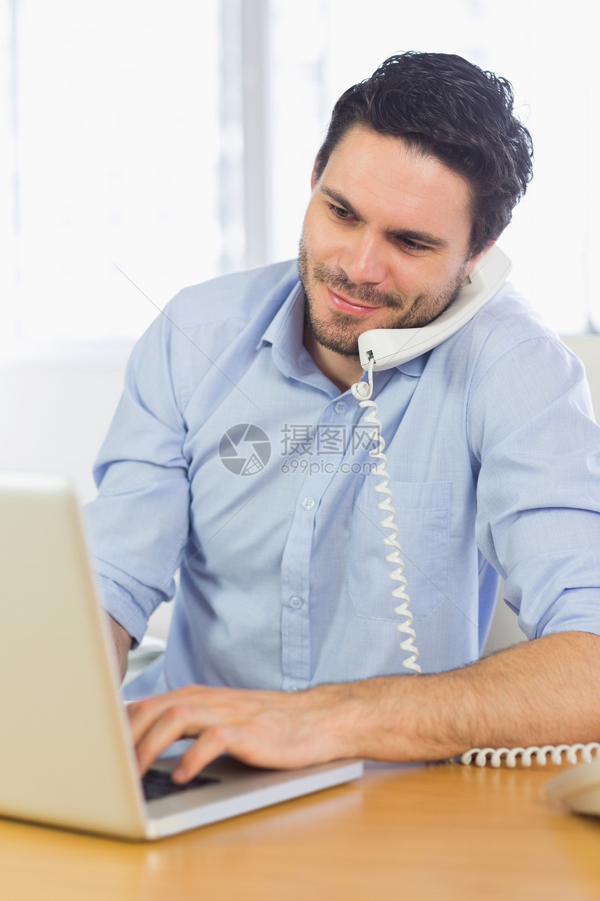 使用笔记本电脑和电话的商务人士人士办公室生意商业男人技术微笑听力职场男性图片