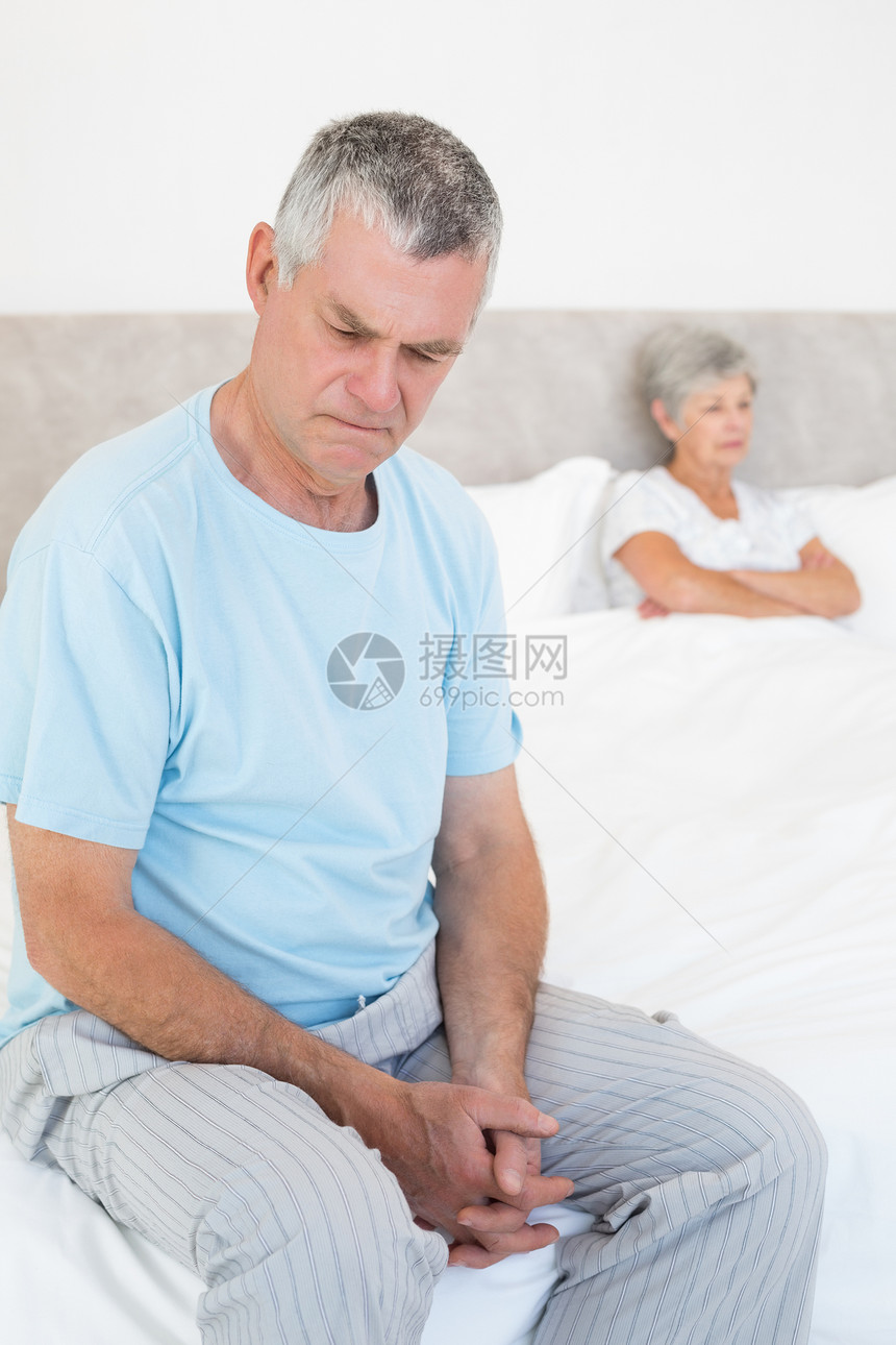 可悲的老年男子和背景妻子在床上图片