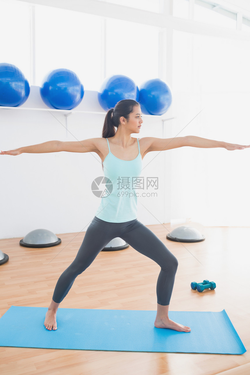 运动青年女子在健身工作室伸手拉手健身室瑜伽身体调子女士背心灵活性运动垫训练双手图片