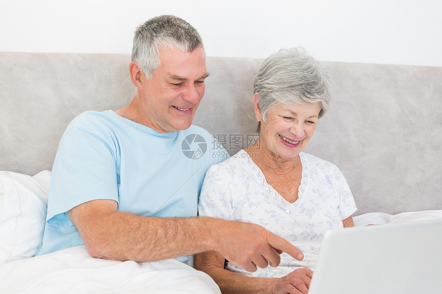 在床上使用膝上型电脑的老年夫妇房子男人妻子白发流金手势技术夫妻丈夫卧室图片