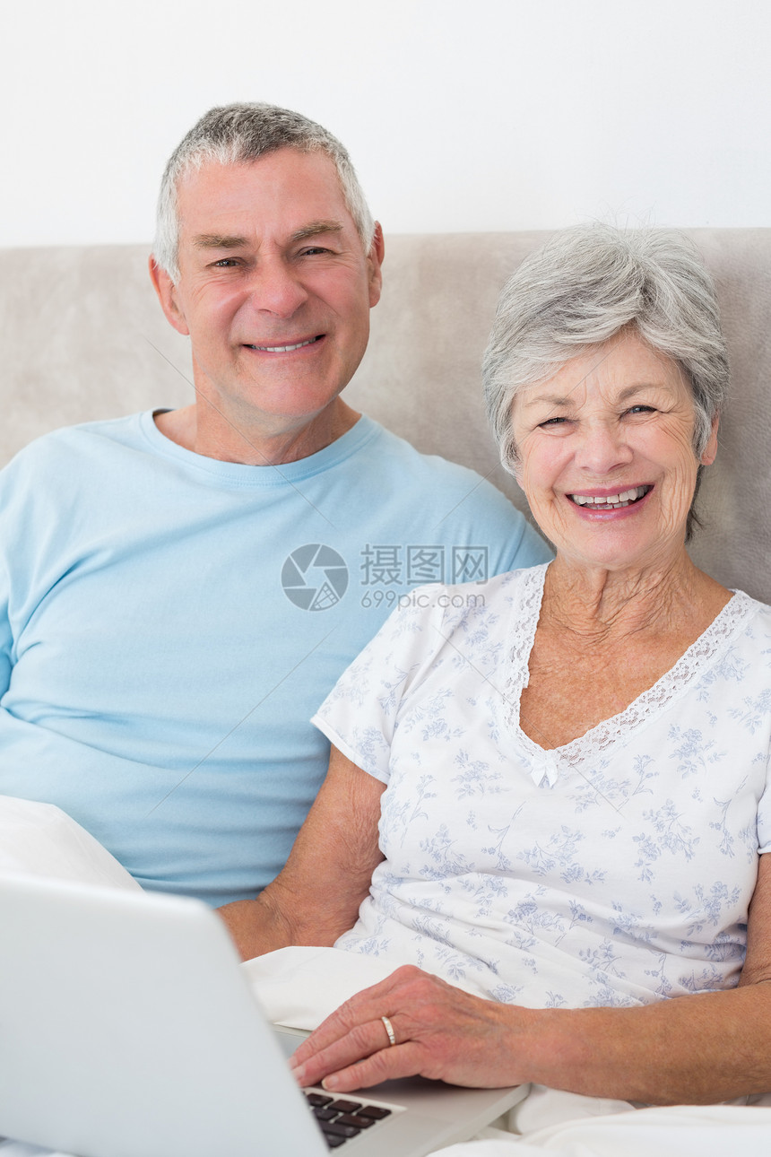 床上有膝上型电脑的老年夫妇白发妻子丈夫男人技术夫妻闲暇男性房子流金图片