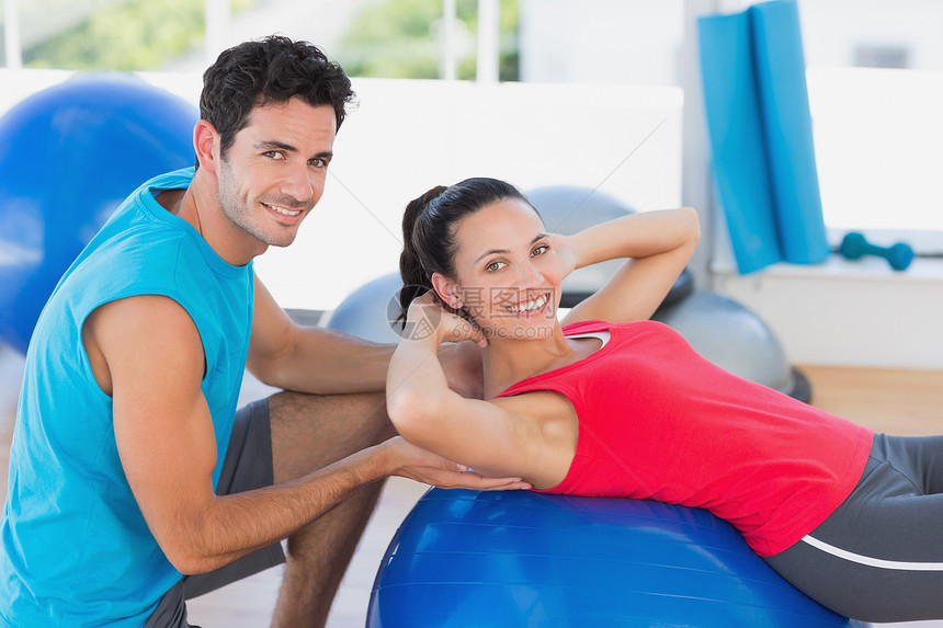 帮助妇女锻炼的男教练员身体火车女性男性健身运动员女士讲师运动服健身房图片