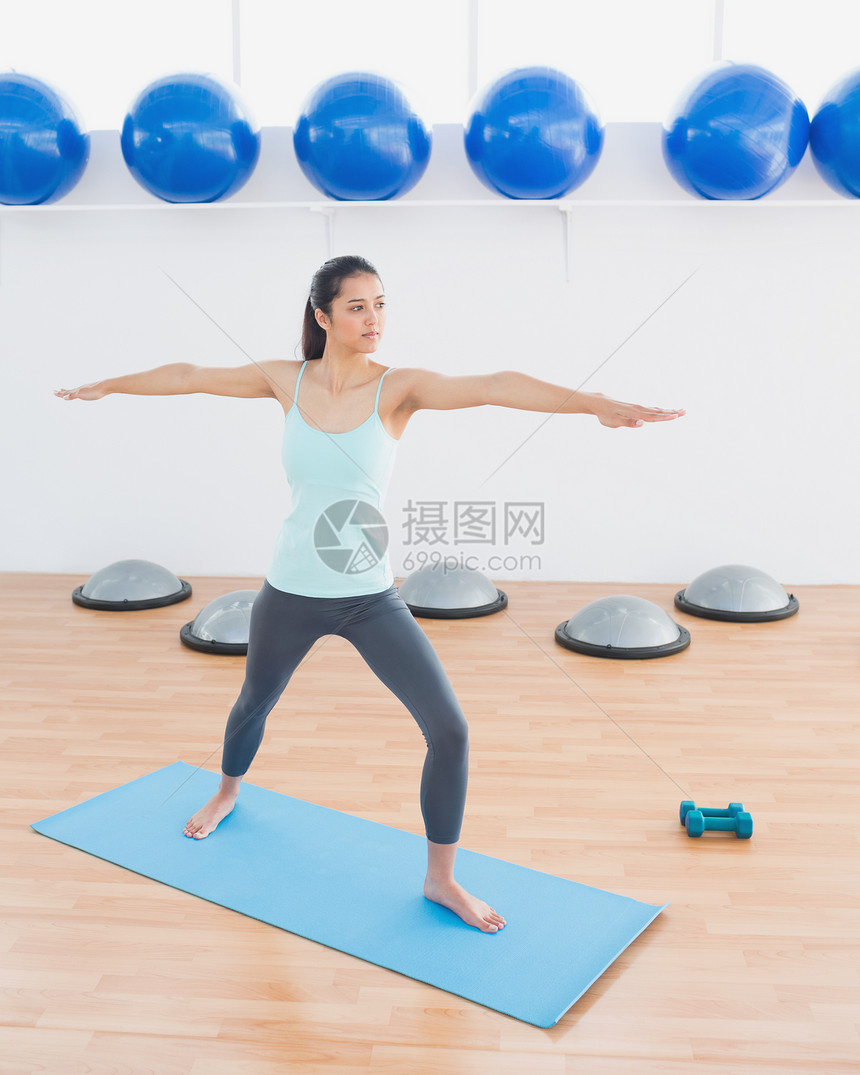 运动青年女子在健身工作室伸手拉手瑜伽姿势背心运动垫调子健身房身体活动女性混血图片