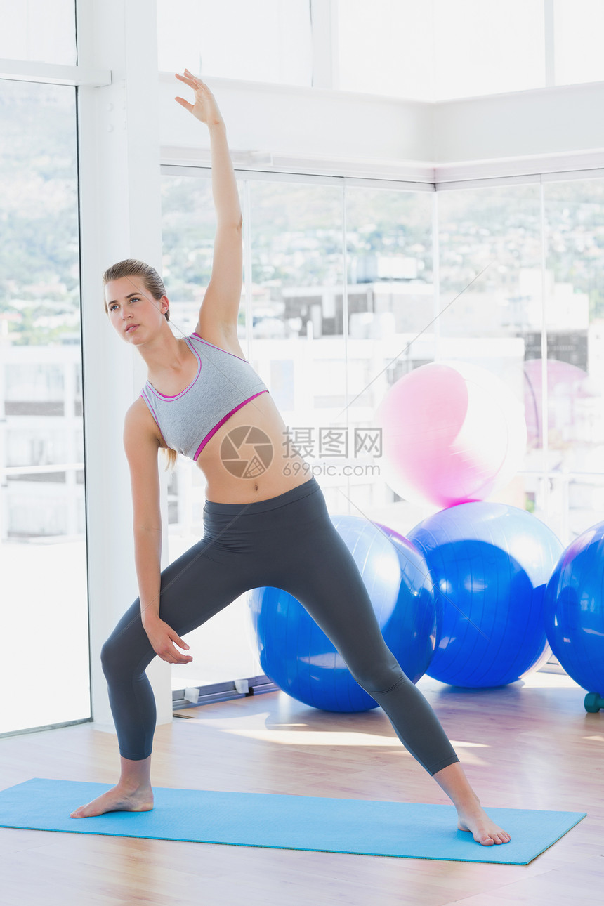 在健身工作室伸手的合适妇女训练护理文胸俱乐部身体灵活性闲暇运动女性运动服图片