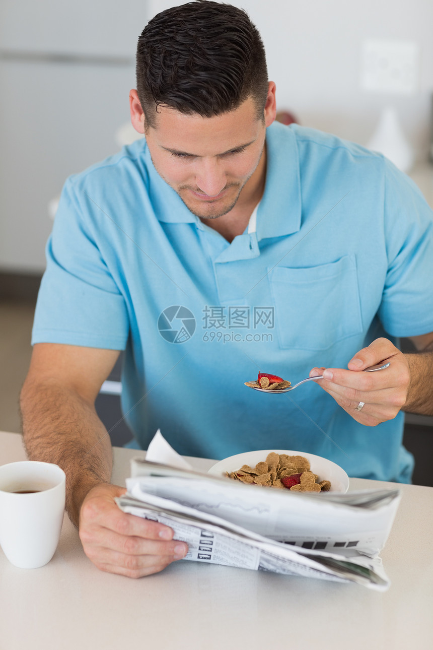 男人在吃早餐时看报纸;图片
