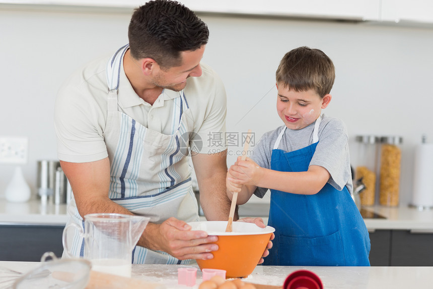 父亲和儿子在柜台做饼干图片
