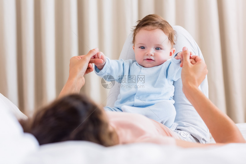 婴儿与母亲在床上玩图片